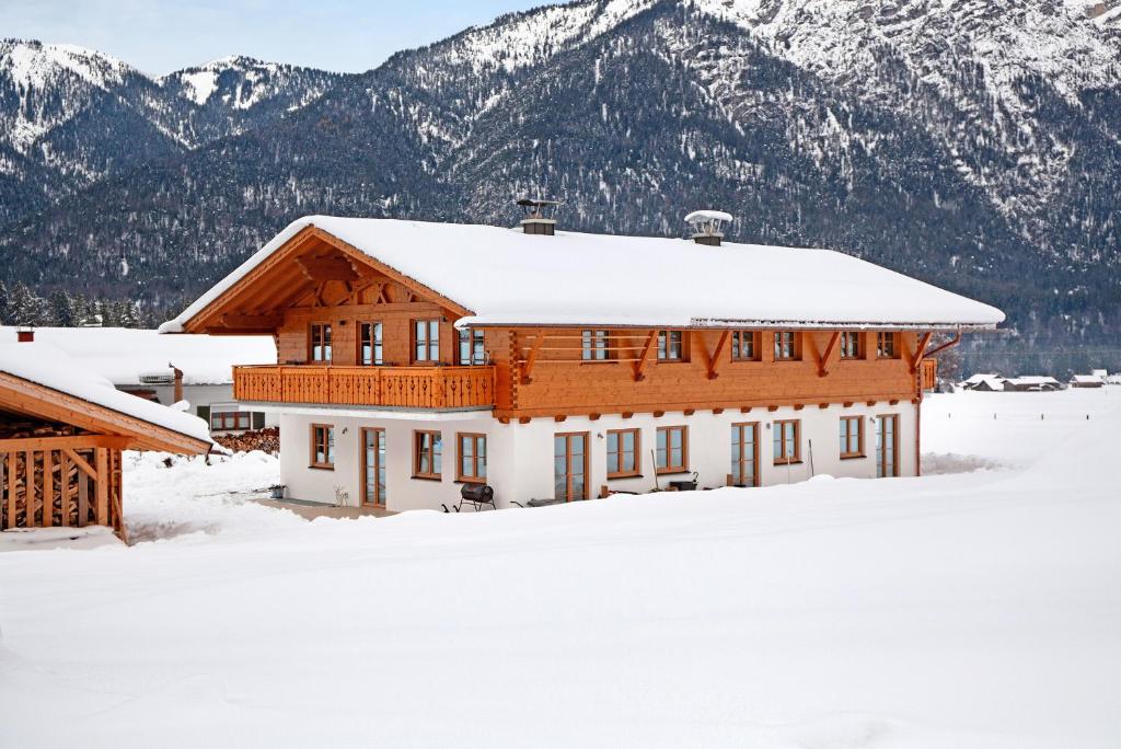 a house covered in snow with mountains in the background at Ferienwohnung Gletschernelke in Grainau