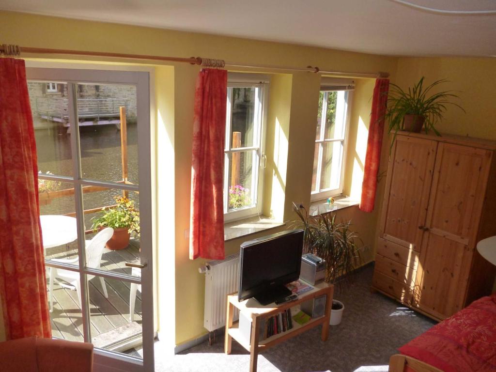 a living room with two windows and a television at Ferienwohnungen Am Breitstrom in Erfurt