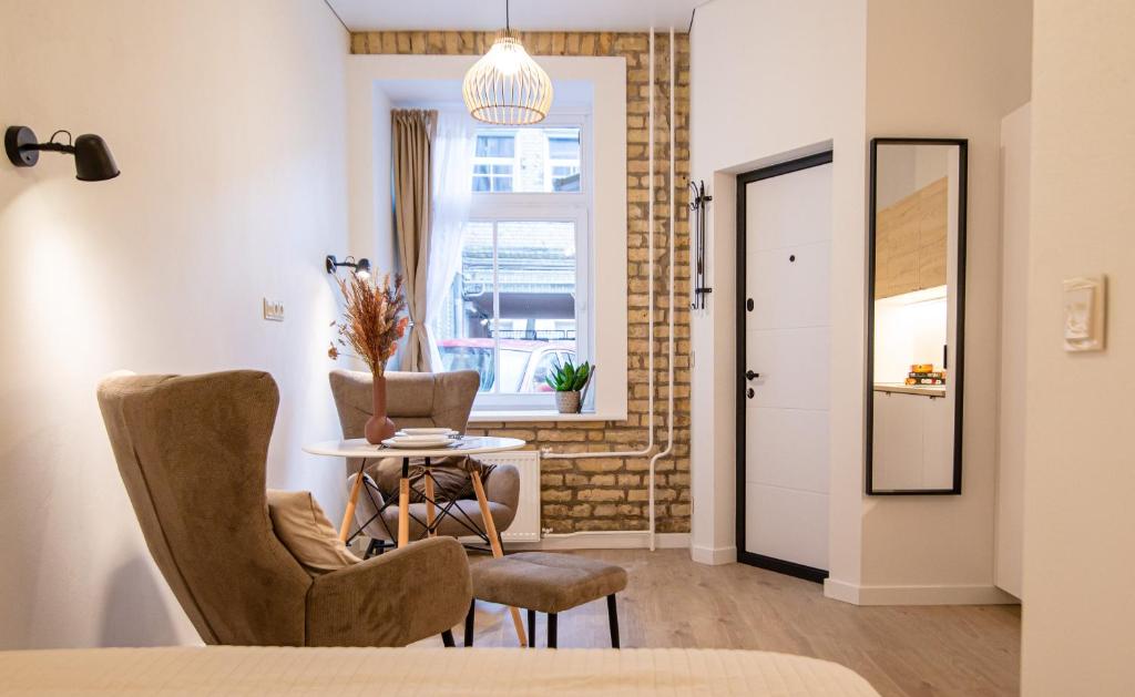 a room with two chairs and a table and a window at Lukiskes square apartments (Oldtown) in Vilnius