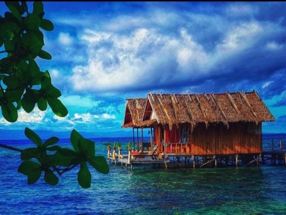 a house on the water in the middle of the ocean at Lalosi Homestay in Besir