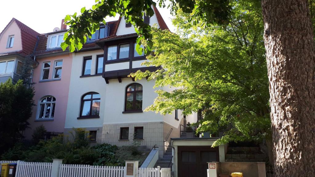 uma casa com uma cerca branca em frente em Ferienwohnung Im Dichterviertel em Erfurt