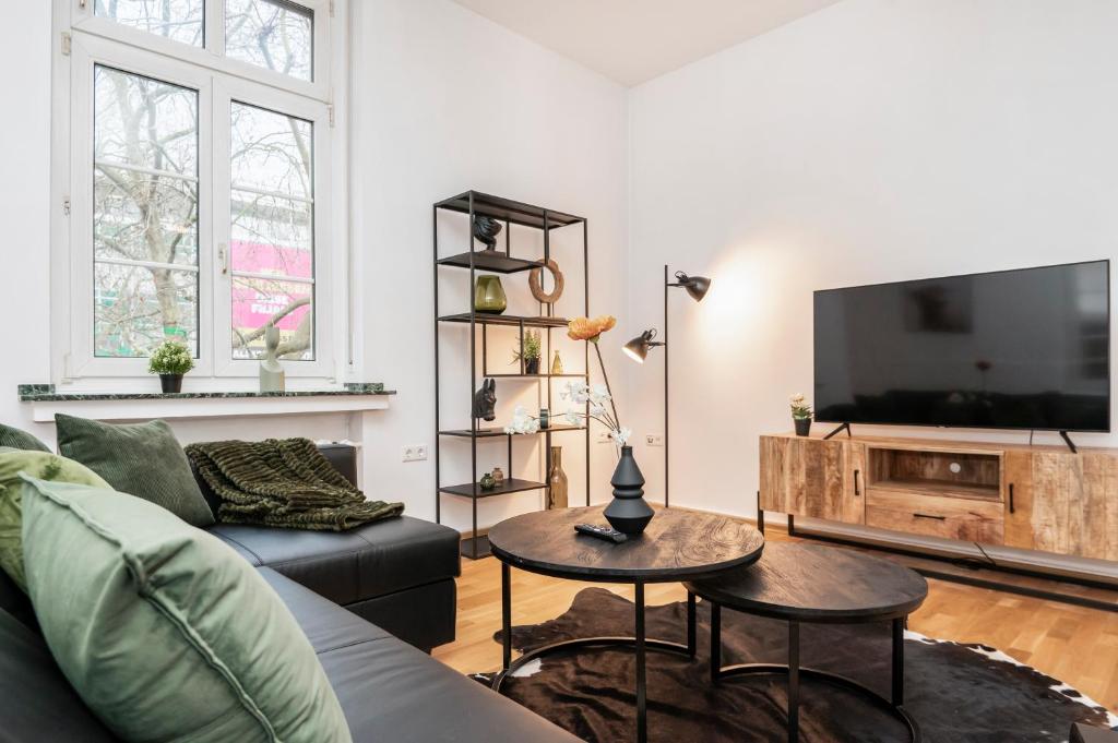 ein Wohnzimmer mit einem Sofa und einem Flachbild-TV in der Unterkunft Center Elegance Light Apartment in Krefeld