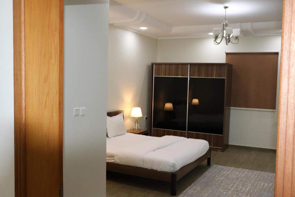 a hotel room with a bed and a mirror at Yanbu Inn Residential Suites in Yanbu