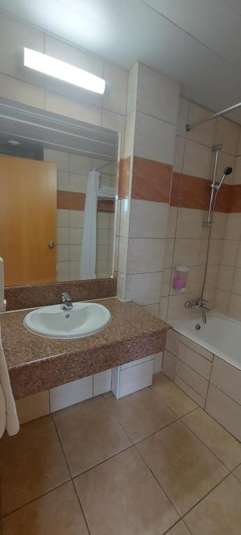 a bathroom with a sink and a bath tub at New Famagusta Hotel & Suites in Ayia Napa