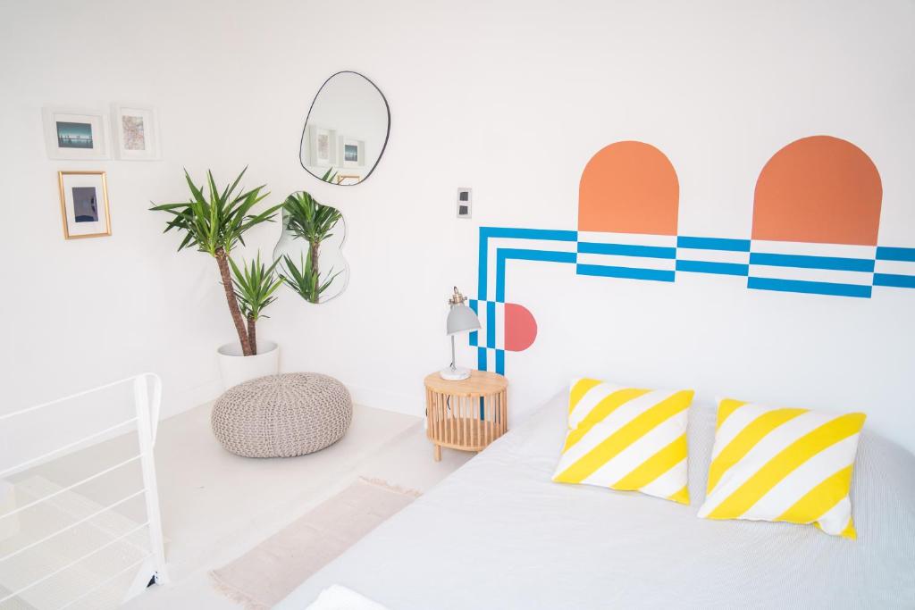 Cette chambre blanche comprend un lit et un miroir. dans l'établissement Duplex au cœur du vieux Nice, à Nice