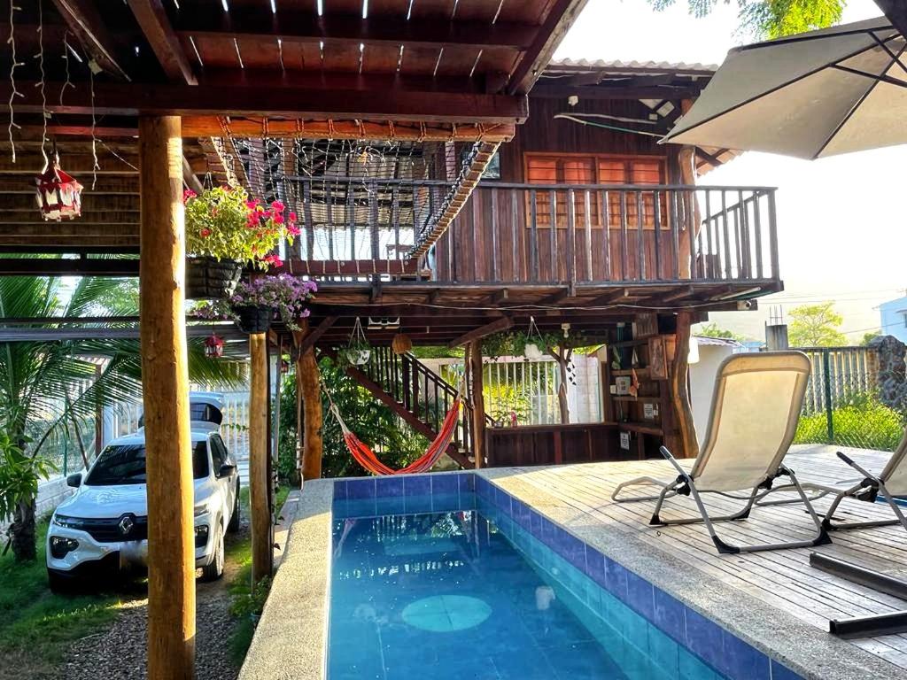 a house with a deck and a swimming pool at Cabaña Caminito- Cerca al mar al lado de Turipaná, 7 a 12 personas in Carretal