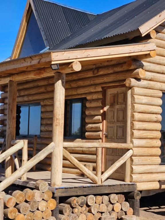 Cabaña de madera con porche y puerta en Estadia de campo en San Andrés de Giles