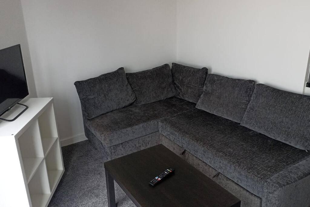 un sofá gris en una sala de estar con mesa de centro en The Boat House 503 en Leicester