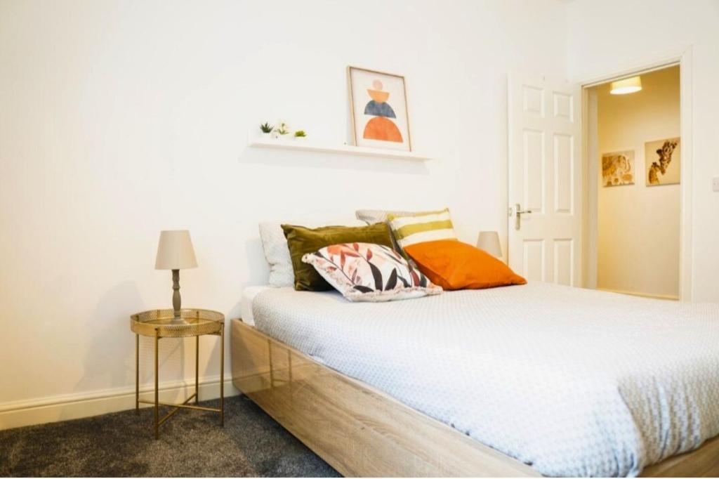 Dormitorio blanco con cama con almohadas en Tudor Tootsies, en Liverpool