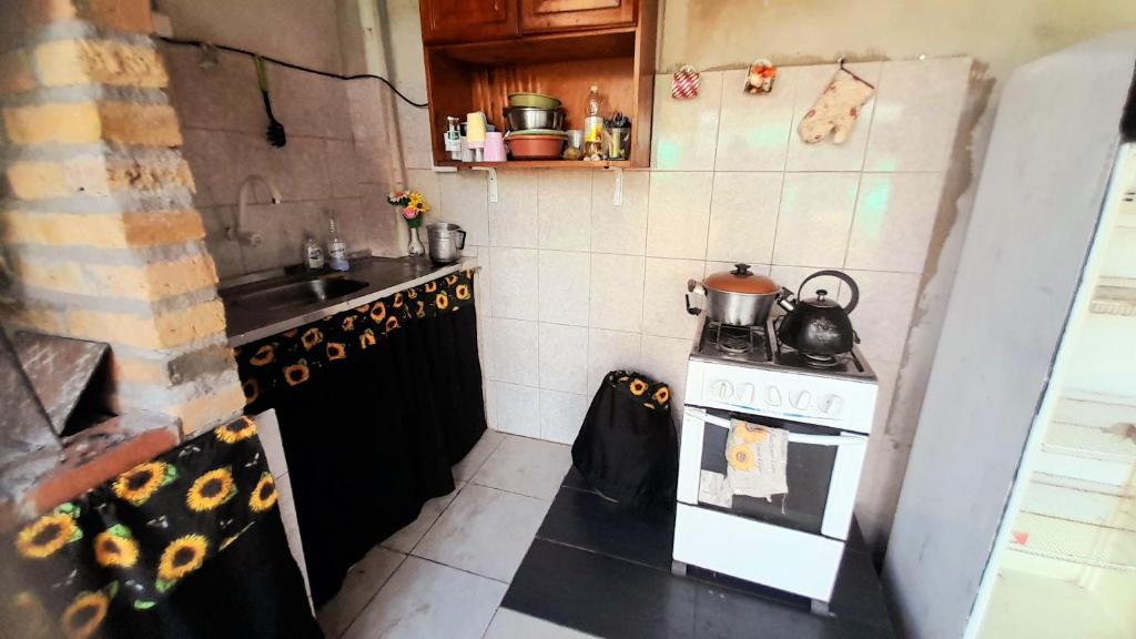 een kleine keuken met een fornuis en een wastafel bij Hostel Loli in Puerto Iguazú
