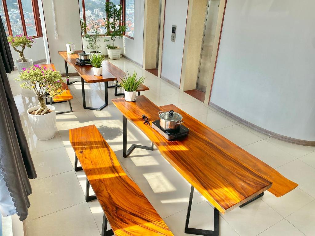 a group of wooden benches in a room with plants at ZoZo House - Homestay Bai Sau 77 in Vung Tau