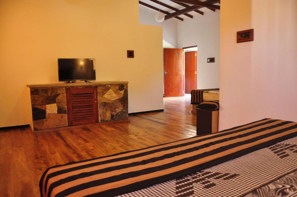 una camera con TV e letto interno di Asantha Guest House a Unawatuna