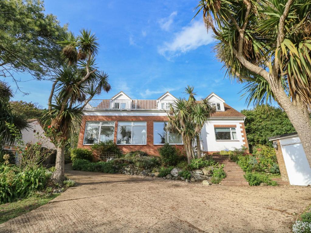 a house with palm trees in front of it at Burwyns in Ventnor