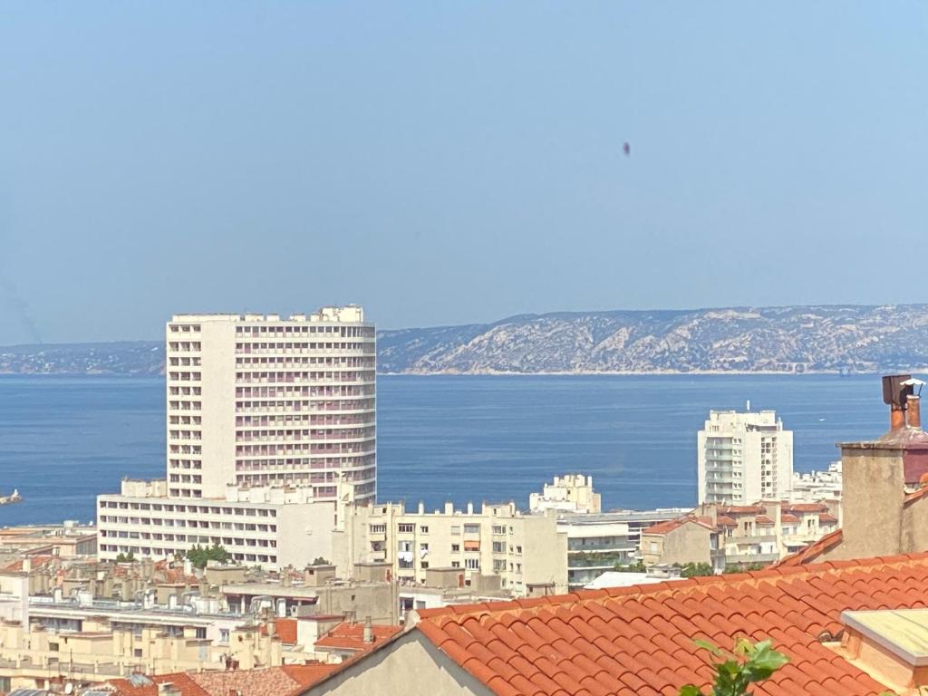 a view of a city with the ocean and buildings at Vue mer - Vue Notre-Dame - Calme - balcon - Climatisation in Marseille