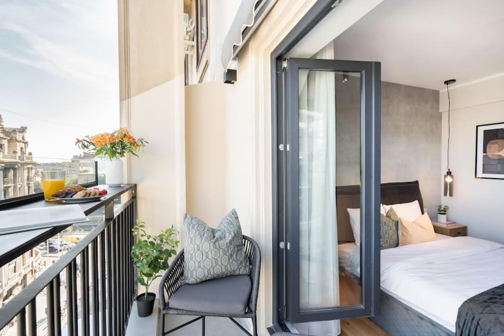 a small balcony with a bed and a chair at Stunning Views Luxury Studio in Bucharest
