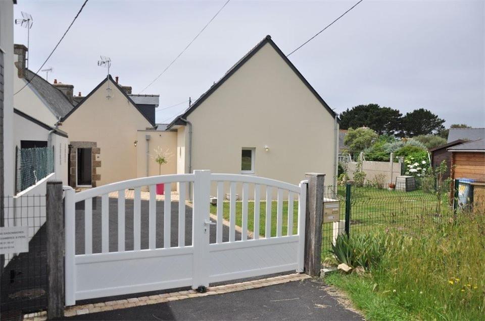 einen weißen Zaun vor einem weißen Haus in der Unterkunft Belle maison avec jardin clos proche plage à l'ILE GRANDE - Réf 291 in Pleumeur-Bodou