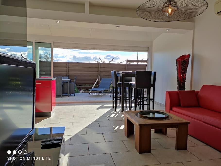 un salon avec un canapé rouge et une table dans l'établissement Villa 112, Port Nature au Village Naturiste, au Cap d'Agde