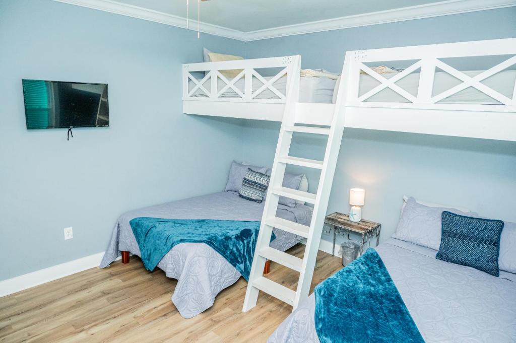 a bedroom with two bunk beds and a ladder at Cottage Beach House Steps From Beach 3 bedroom 2 bath in Gulf Shores