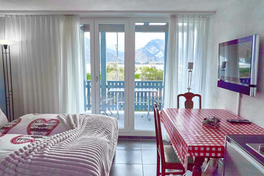 una camera con tavolo e letto e un balcone di Lake apartment by Interlaken a Därligen