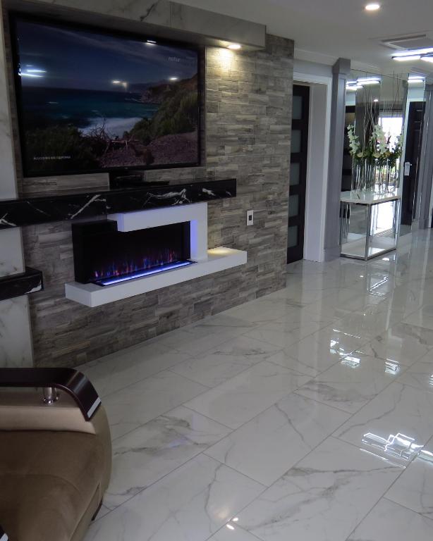 a lobby with a fireplace and a tv on a wall at Dockside Suites in Digby