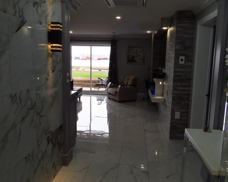 a hallway with a large marble floor and a living room at Dockside Suites in Digby