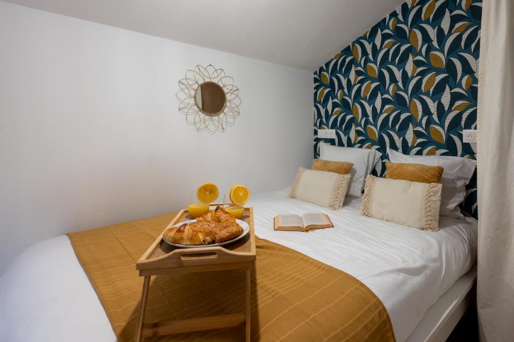 a bedroom with a bed with a tray of food on it at Le Mimi Mosa - Parking public gratuit, wifi haut débit, proche autoroute, gare & centre ville in Mâcon