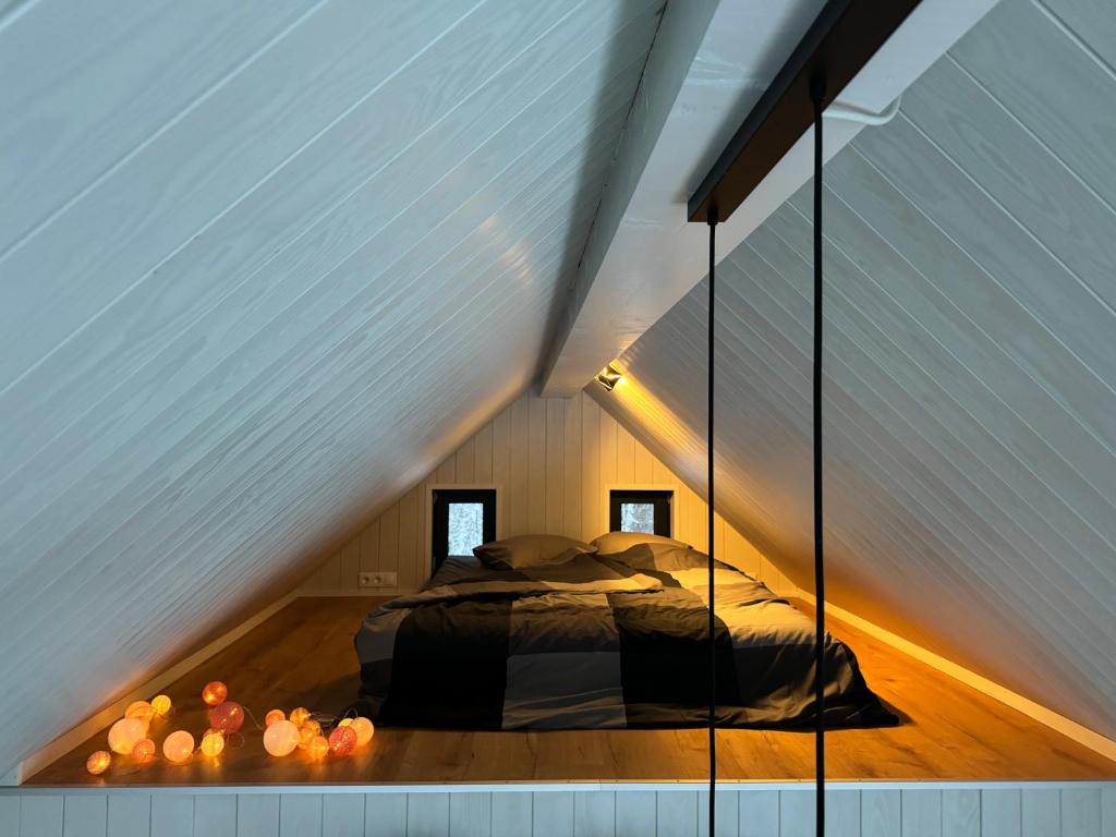 a room with a bed in the middle of a attic at Ozola stāsts atpūtas namiņš 