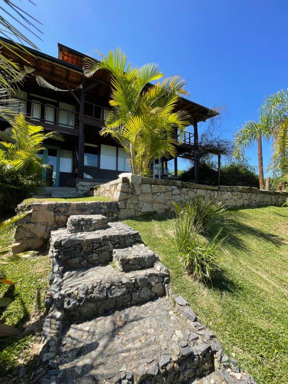 a stone pathway in front of a house at Casa Fluila in Praia do Rosa