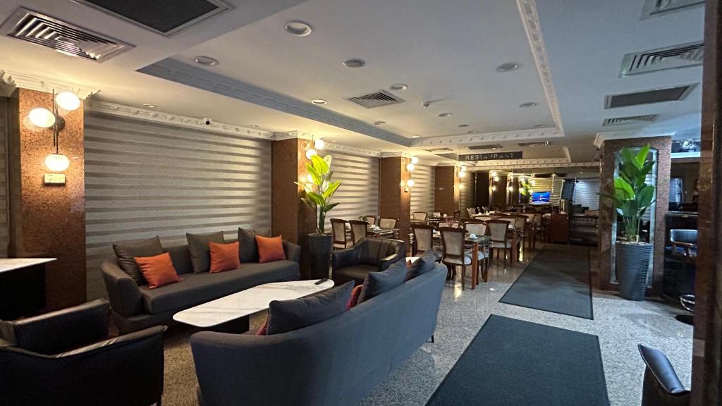 イスタンブールにあるGrand Hotel Seferoğluのソファ、テーブル、椅子が備わるレストラン