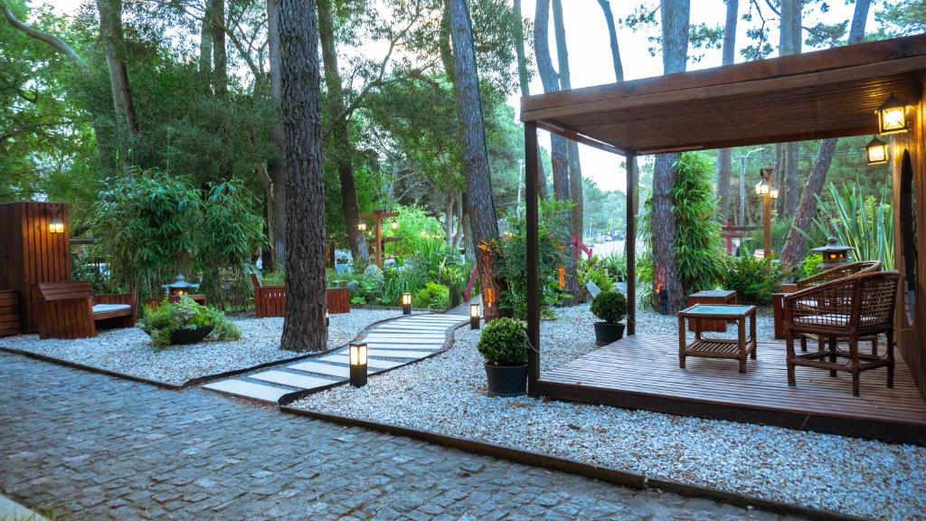 un pabellón con mesa y sillas en un jardín en Mizu Hotel Boutique en Mar de las Pampas