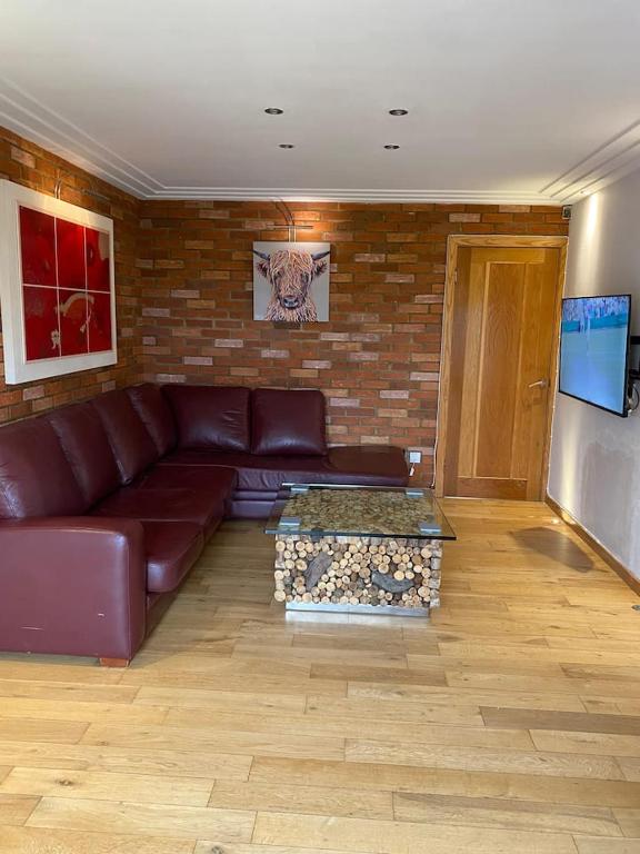 a living room with a couch and a brick wall at Luxury 2 Bedroom Aparmant in Morley in Morley