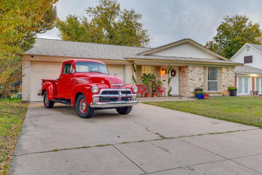 an old red truck parked in front of a house at Arlington Vacation Rental, Walk to ATandT Stadium! in Arlington