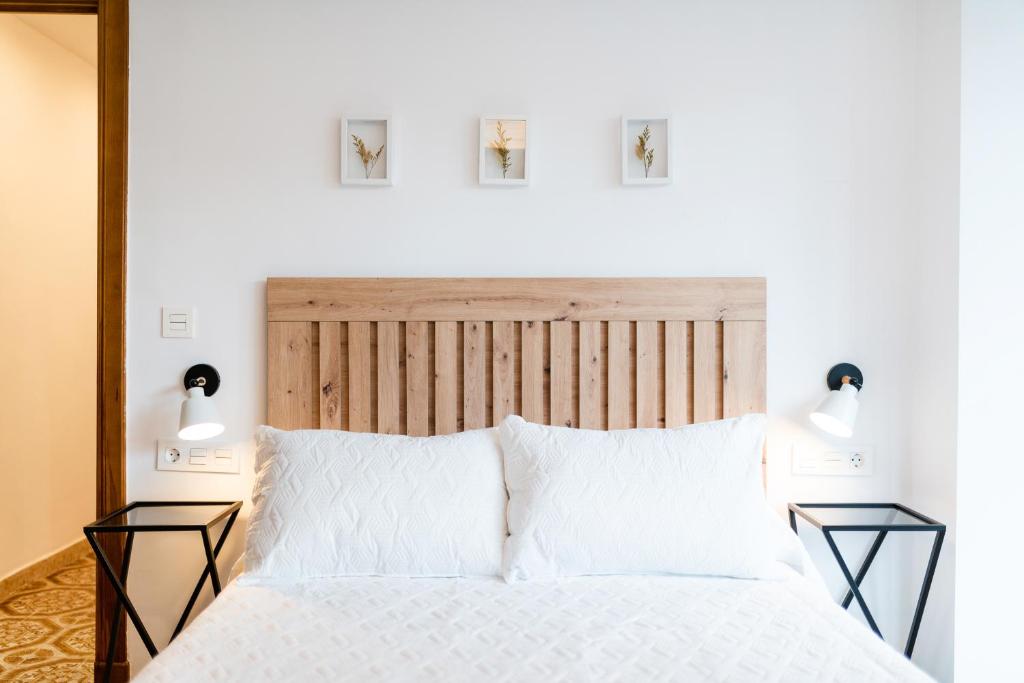 a bedroom with a large white bed with two lamps at Piso junto a Parque de las Ciencias en Granada in Granada