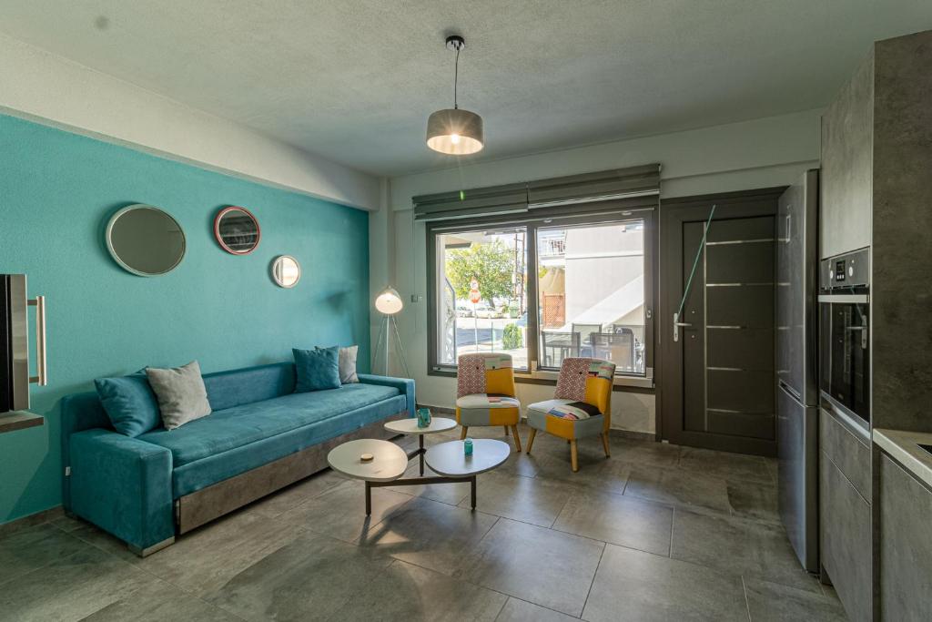 salon z niebieską kanapą i krzesłami w obiekcie STREET 90 Lux Aparts w mieście Keramotí