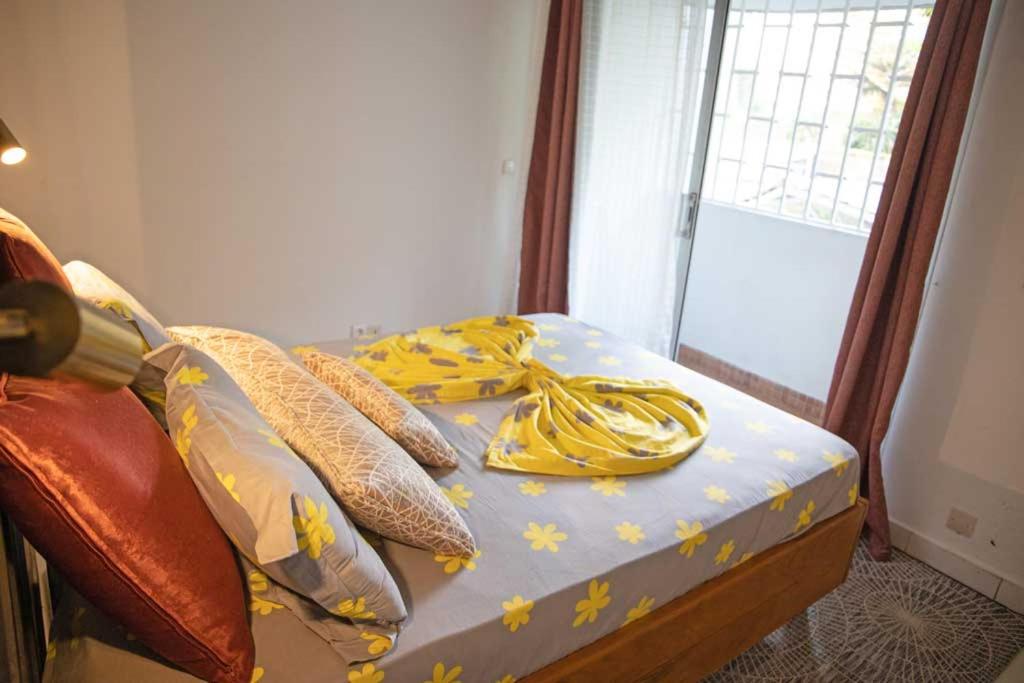 a bed with a blue sheet with yellow stars on it at Beach apt w/ parking, 24/7 security, tennis court in Libreville