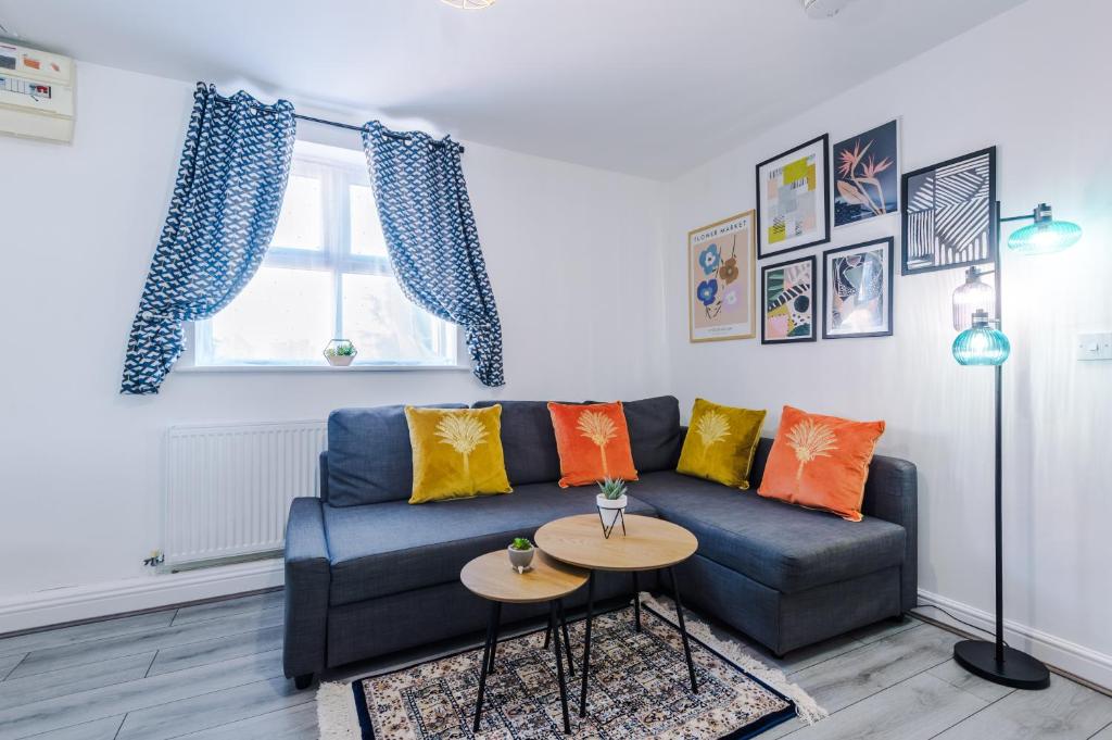 a living room with a blue couch and a table at The Davidson Serviced Apartment Coventry in Coventry