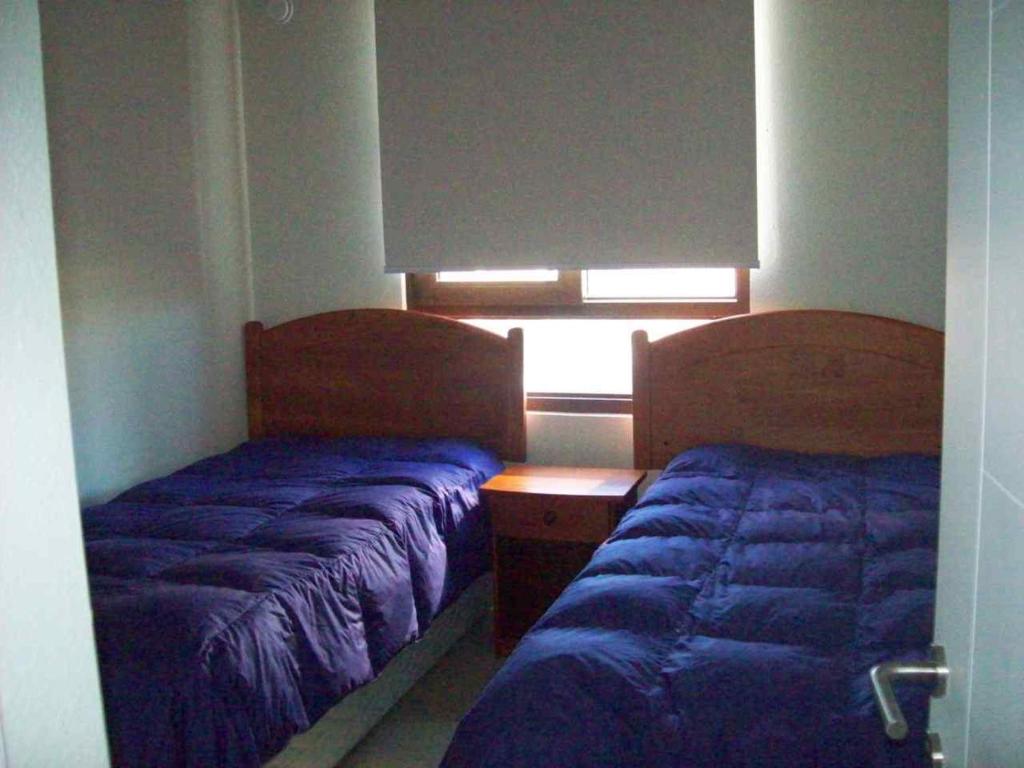 two beds in a room with a window at Jardin del Mar in Coquimbo