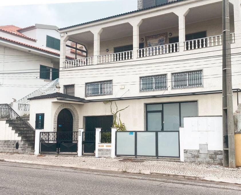 un edificio blanco con balcón en la parte superior en GH Odivelas - Quartos em Casa com Bilhar! 