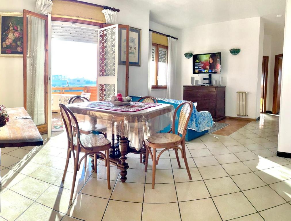 uma sala de estar com uma mesa de jantar e cadeiras em Stella Di Mare - ampio appartamento con doppi servizi - fronte mare em Lido di Ostia