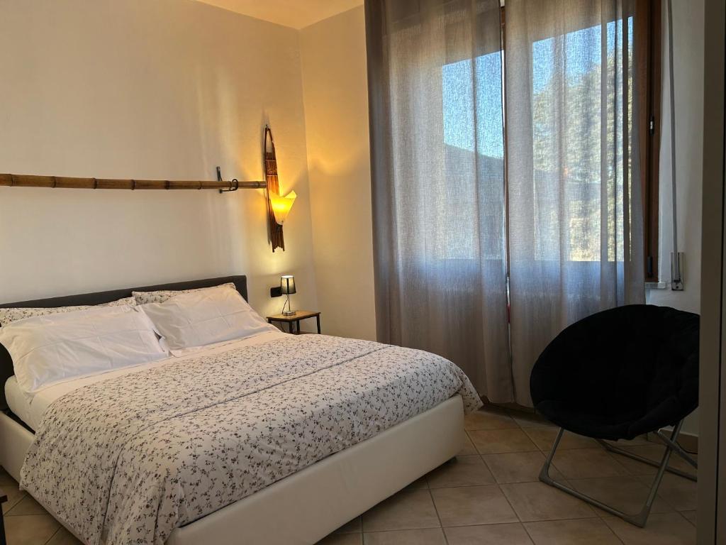 ein Schlafzimmer mit einem Bett, einem Stuhl und einem Fenster in der Unterkunft La Corte di Silvia Malpensa in Cardano al Campo