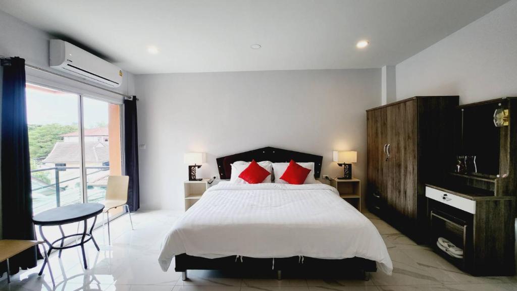 1 dormitorio con 1 cama grande con almohadas rojas en PR ROOM FOR RENT en Kamala Beach