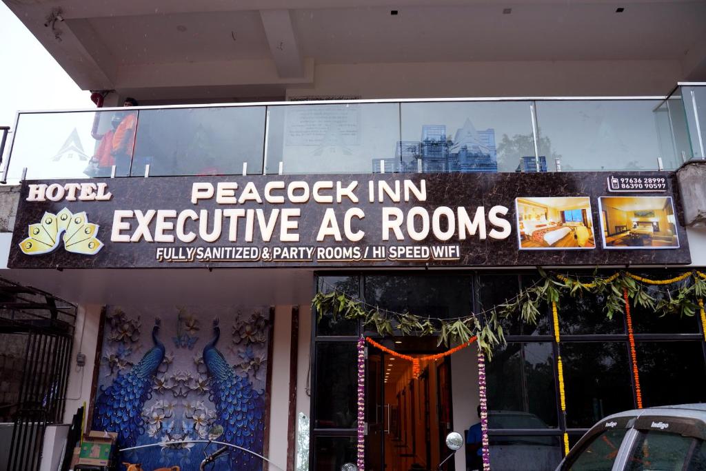 a sign for aacco inn executive ac rooms on a building at HOTEL PEACOCK INN 