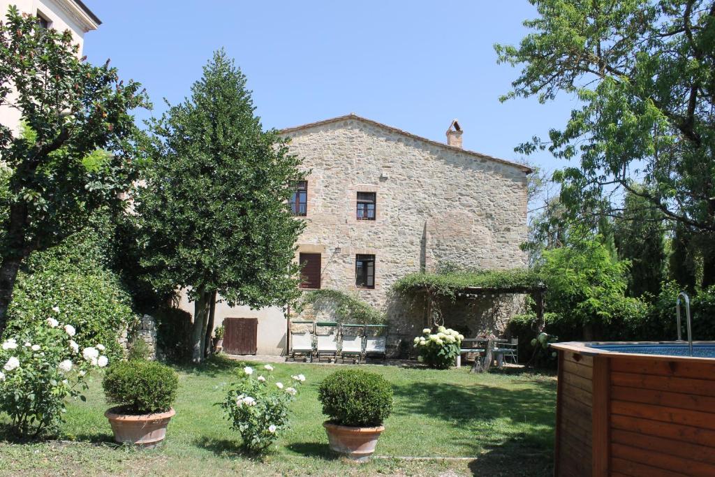 un vecchio edificio in pietra con piante in un cortile di Casa Demo a Fighine