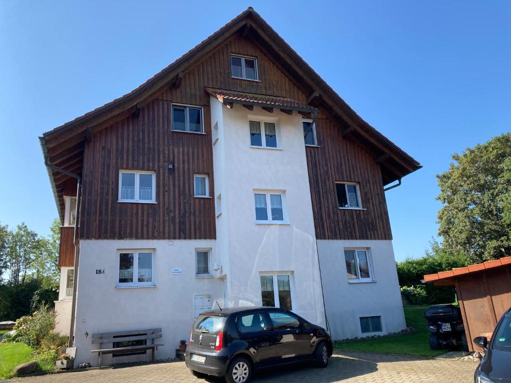 a large wooden house with a car parked in front at Ferienwohnung Oflings in Wangen im Allgäu