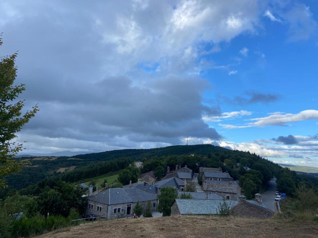 un villaggio in cima a una collina con case di Habitaciones Frade a O Cebrero