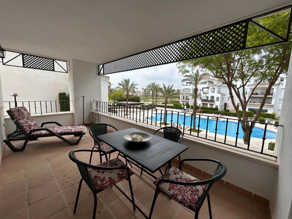 balcón con mesa, sillas y vistas a la piscina en 2 bedroom apartment overlooking pool - MO4012LT, en Los Tomases