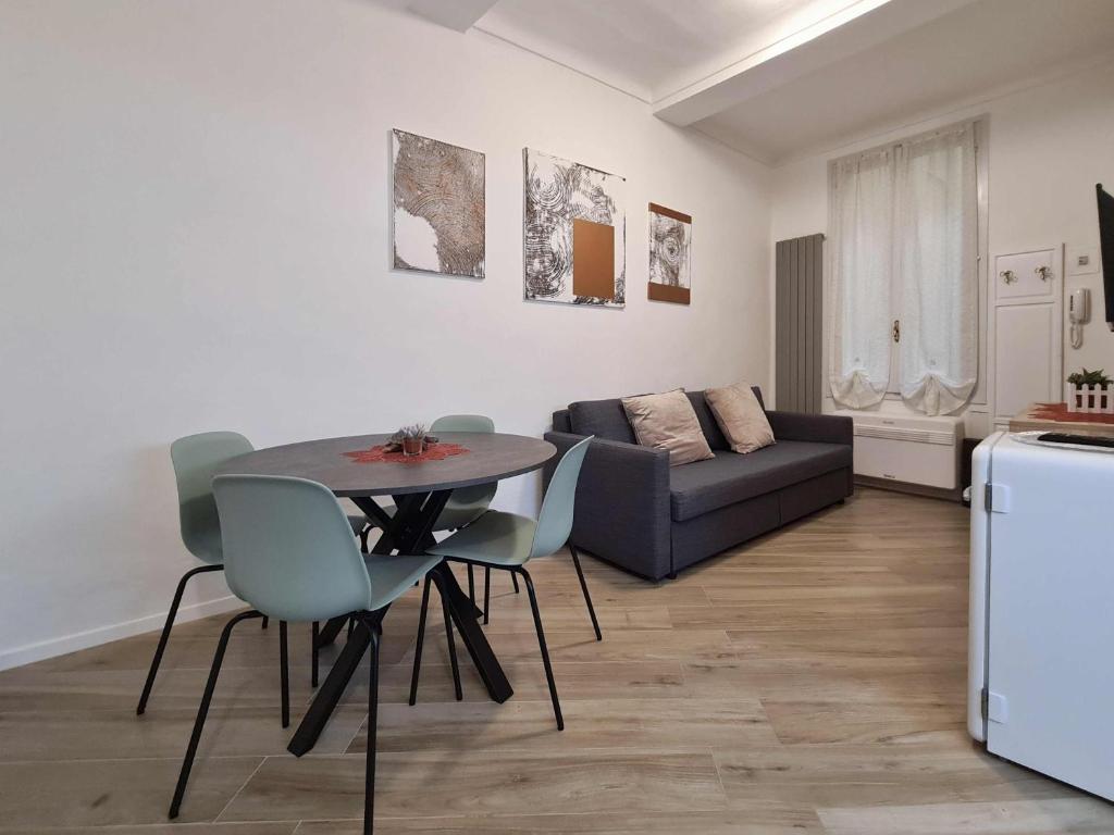 un soggiorno con tavolo, sedie e divano di Residenza Tulipano - Modena Dom a Modena