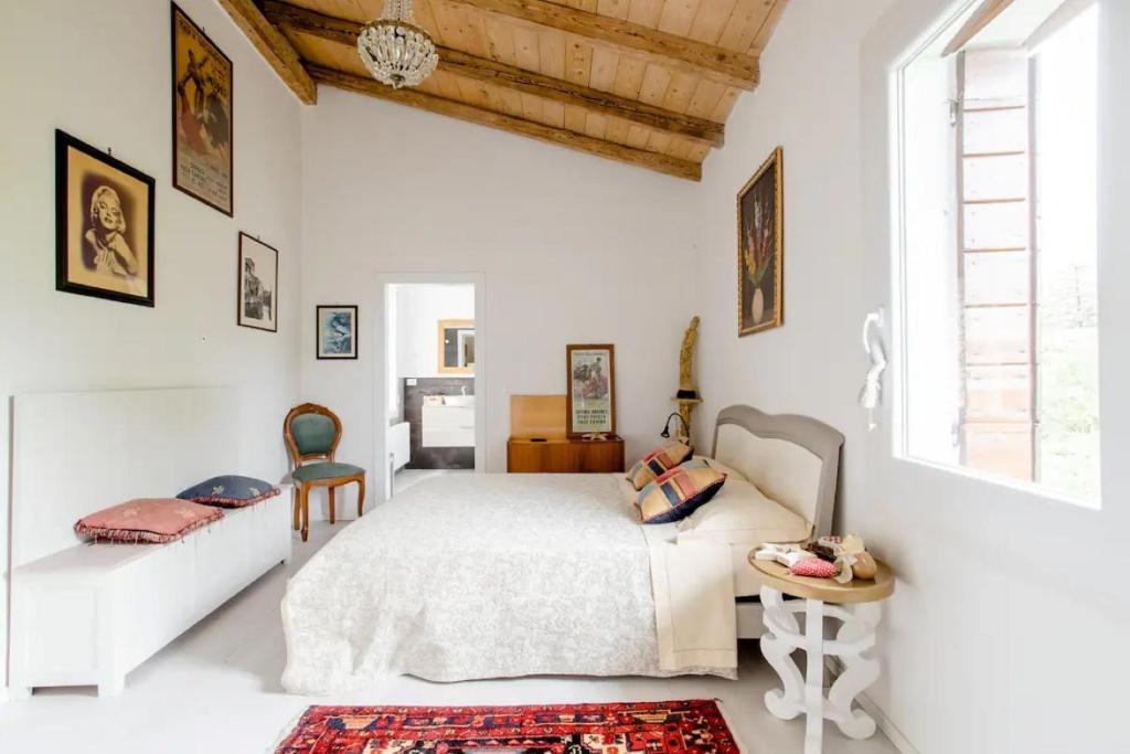 Un dormitorio blanco con una cama grande y una ventana en B&b Ernestine, en Caneva