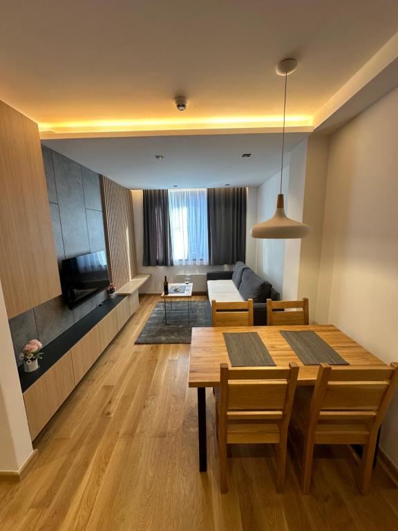 a living room with a table and a couch at Apartman Viktor 302 - Zlatni Javor in Jahorina
