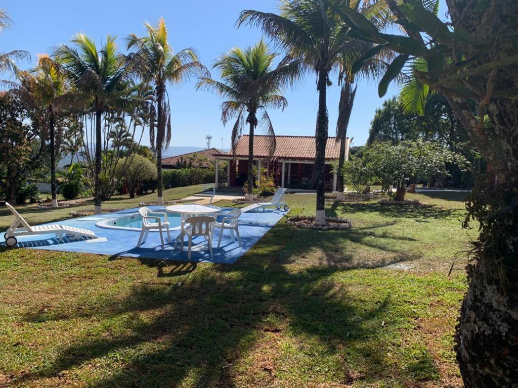 a pool with a table and chairs next to a house at Águas de São Pedro/Water Park: 2 Casas c/ piscina in Águas de São Pedro